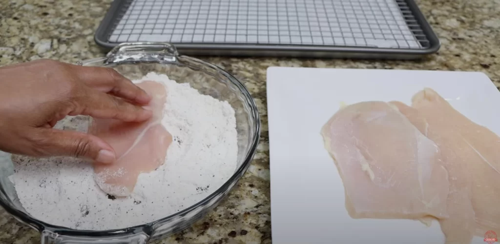 coating the chicken breast with flour